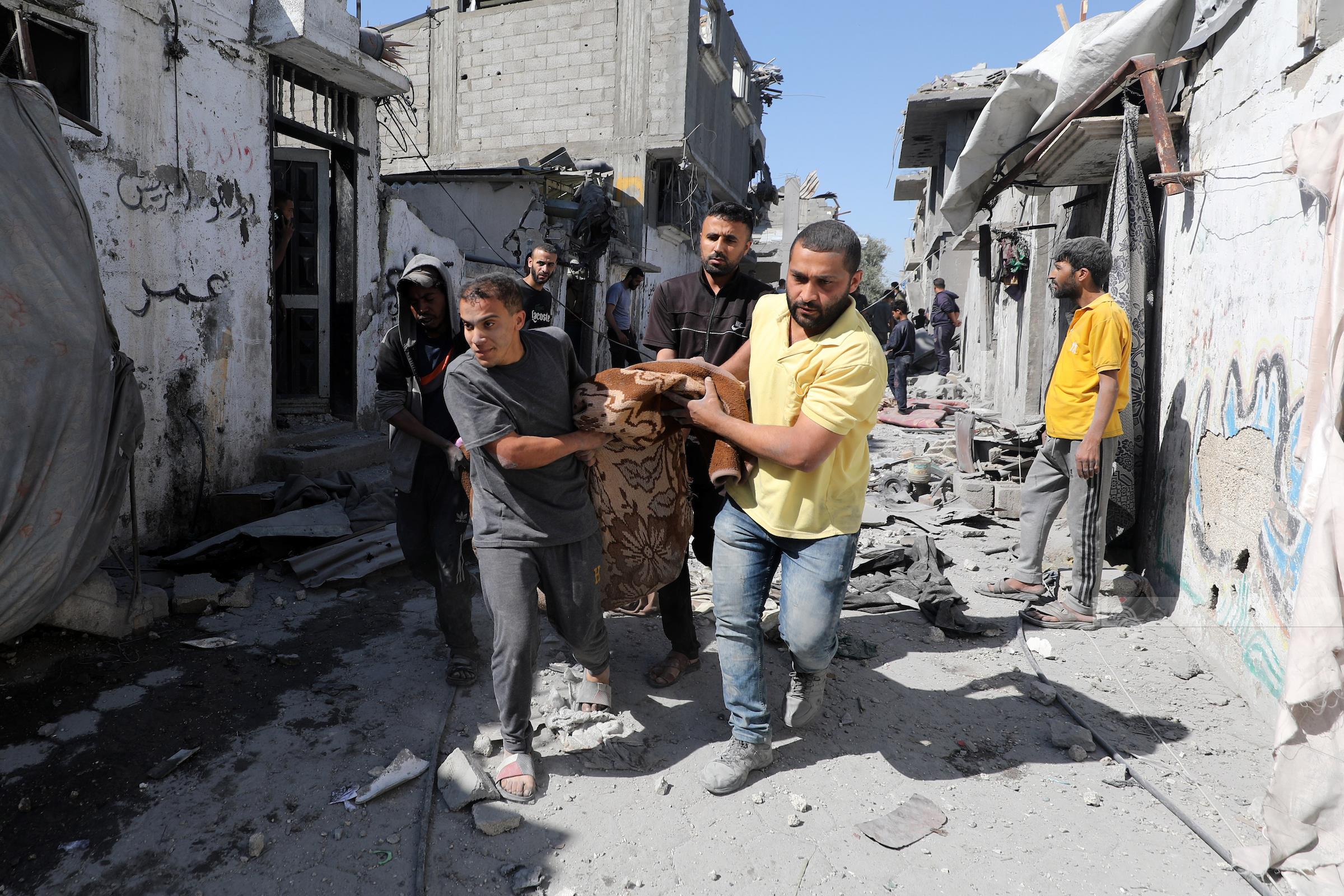 مواطنون ينتشلون شهداء في مخيم البريج وسط قطاع غزة‎. (أرشيف وفا)